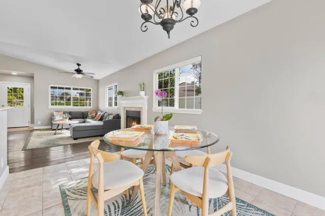 a dining room with wooden floor a chandelier a wooden table and chairs