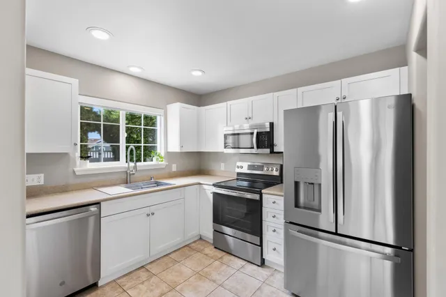 a kitchen with stainless steel appliances a refrigerator stove microwave and sink