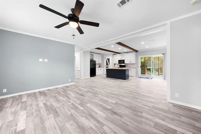 a view of empty room with wooden floor and ceiling fan