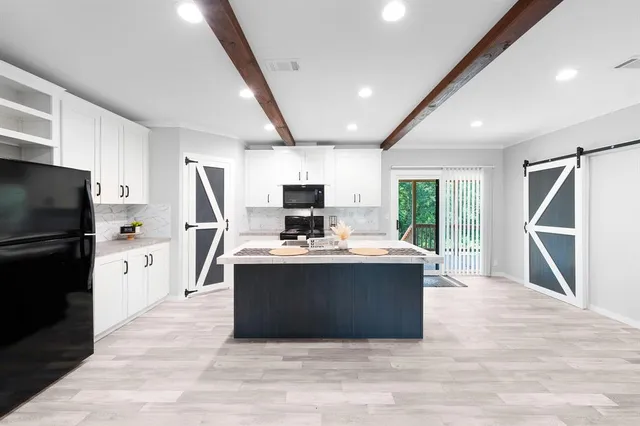 a view of kitchen with microwave stove refrigerator and cabinets