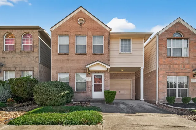 a front view of a house with a yard and potted plants