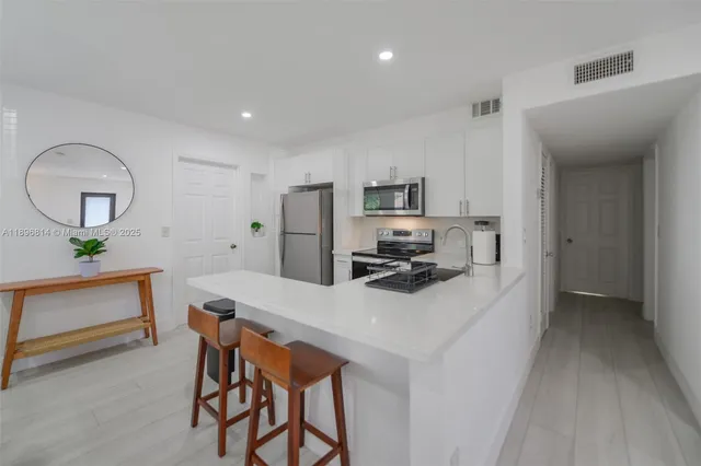 a kitchen with a refrigerator a stove and a sink