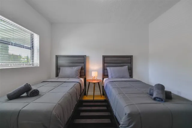 a bedroom with two beds and a window