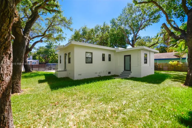 a view of backyard of house with green space