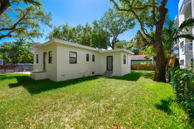 a view of backyard of house with green space