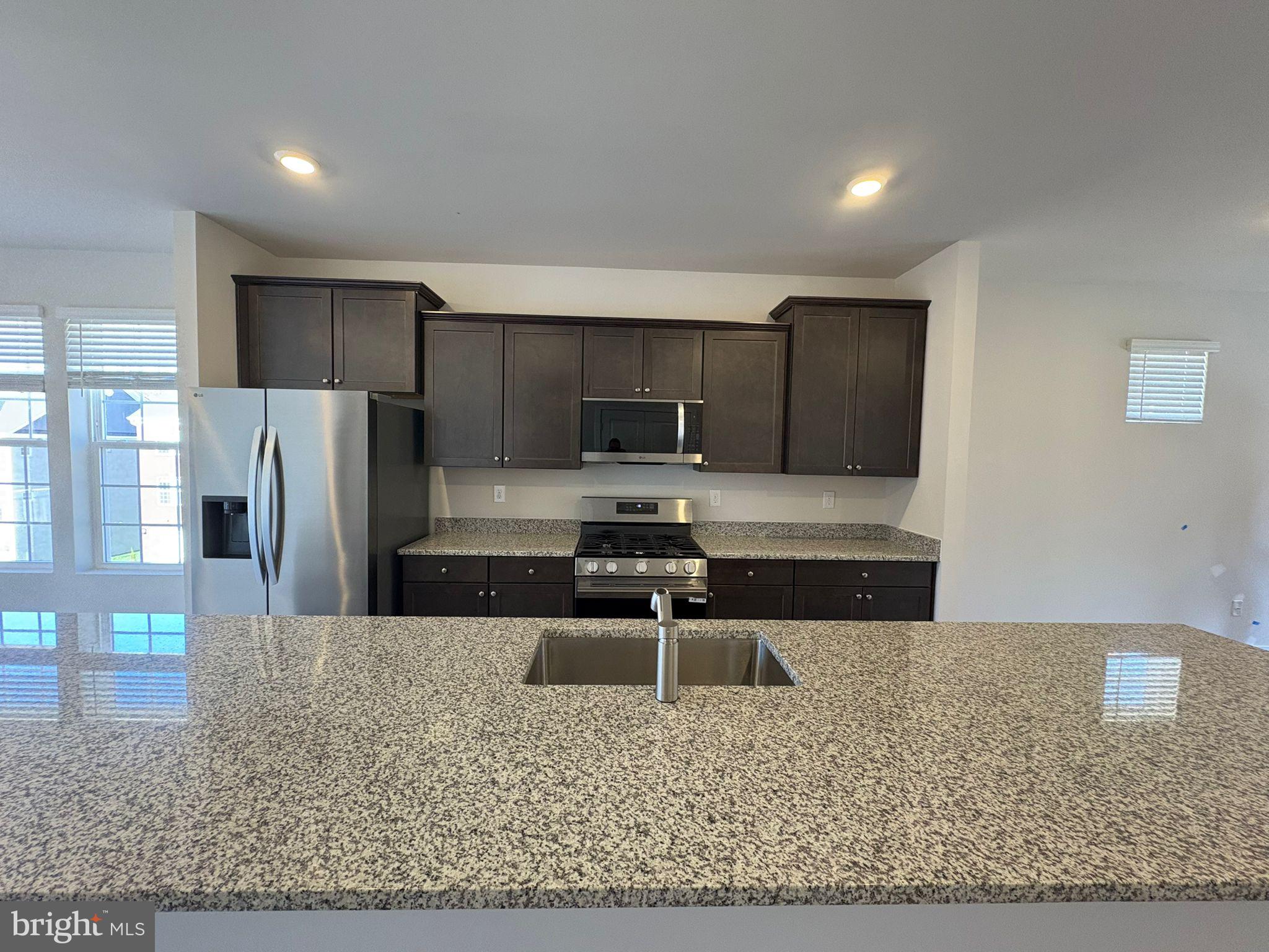 a kitchen with stainless steel appliances granite countertop a stove a sink and a refrigerator