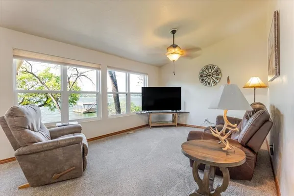 a living room with furniture a flat screen tv and a large window