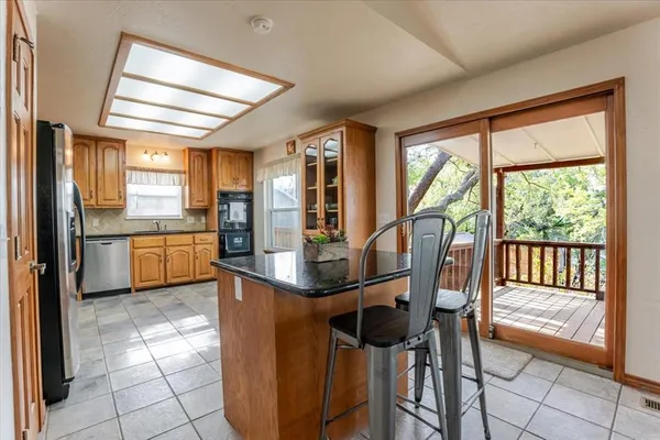 a kitchen with stainless steel appliances granite countertop a stove top oven a sink and a refrigerator