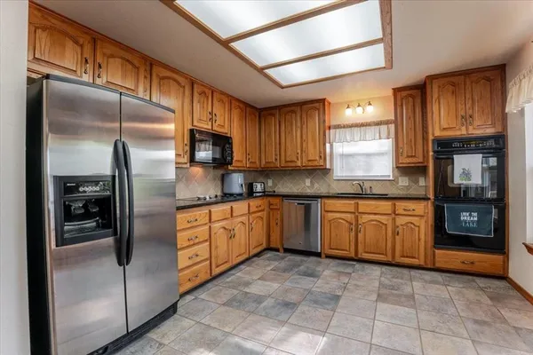 a kitchen with stainless steel appliances granite countertop a refrigerator and cabinets