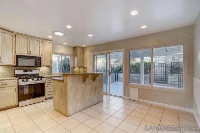 a kitchen with stainless steel appliances granite countertop a stove top oven a sink and a refrigerator