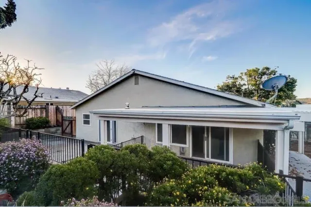 a view of a white house next to a yard