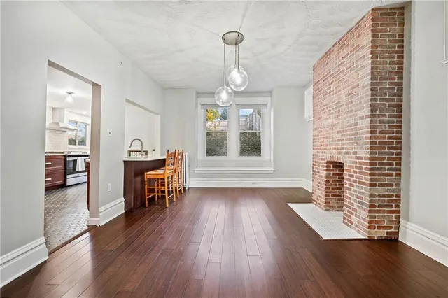 a view of empty room with wooden floor and fireplace