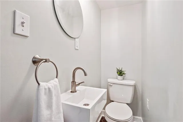 a bathroom with a toilet sink and a mirror