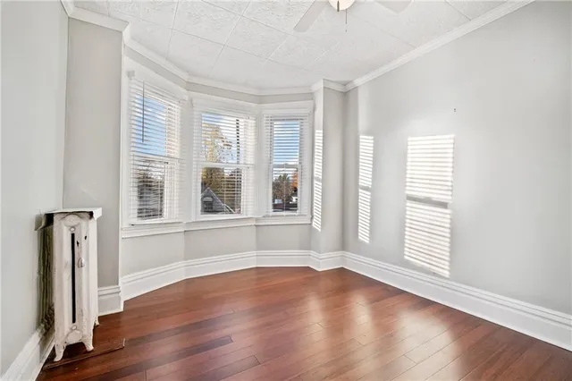 an empty room with wooden floor and a window