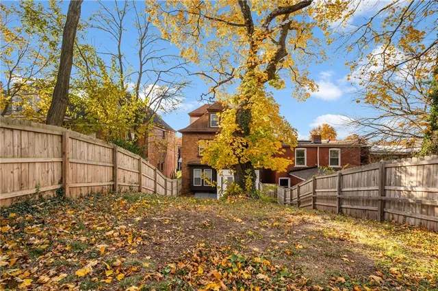 a view of a yard with wooden fence