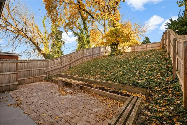 a view of a small house with backyard and wooden fence