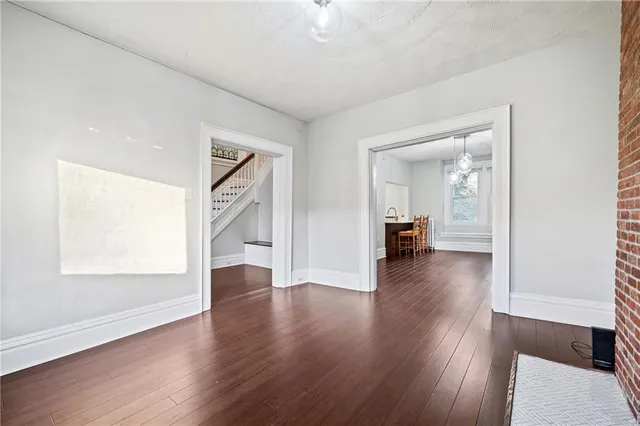an empty room with wooden floor and a window