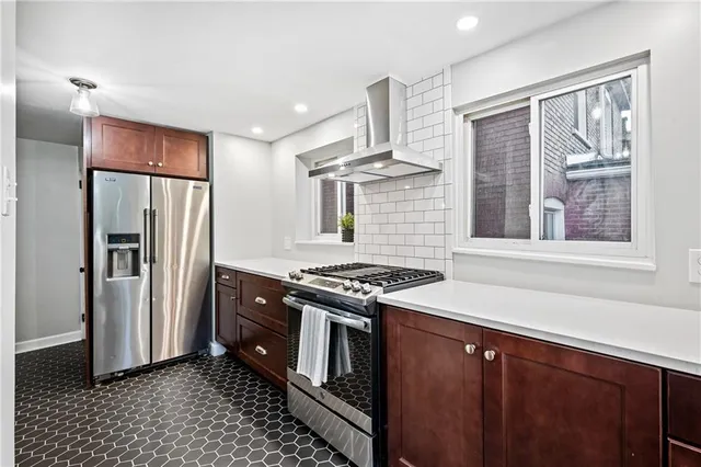 a kitchen with stainless steel appliances granite countertop a stove a refrigerator and a sink