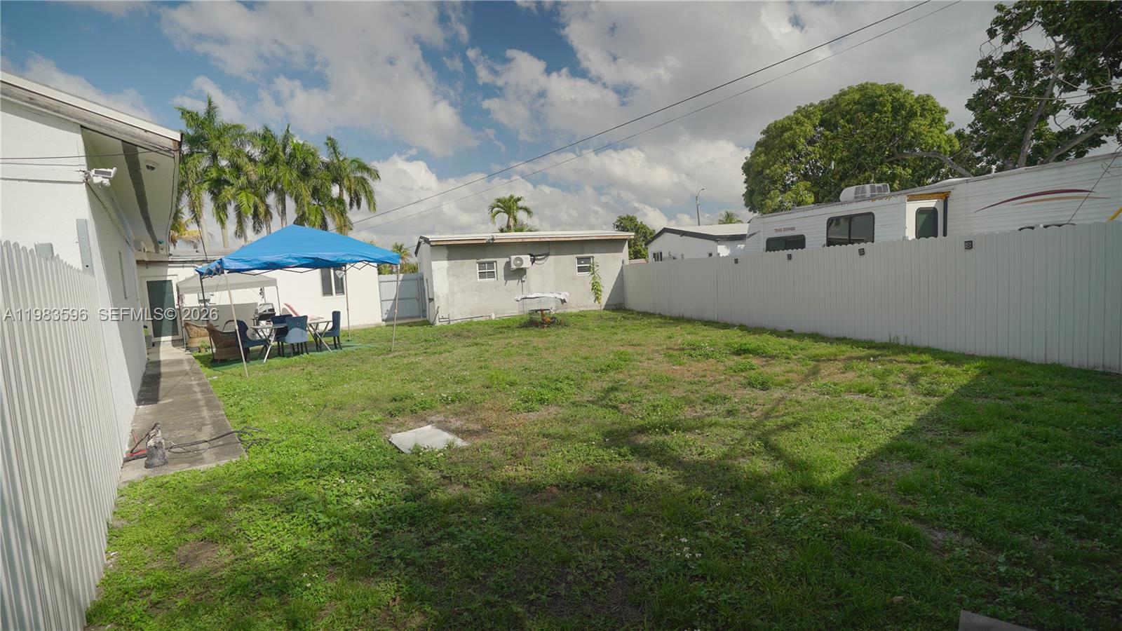 1720 Northwest 124th Terrace Miami, FL 33167 - Photo 17 of 73 a view of a house with a yard and table under an umbrella