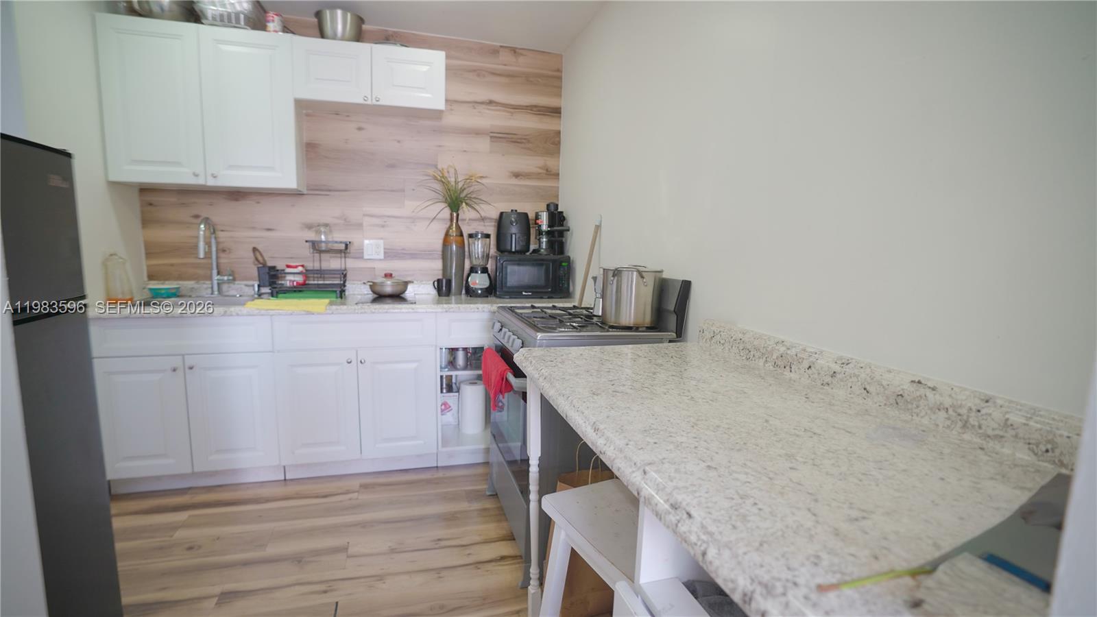 1720 Northwest 124th Terrace Miami, FL 33167 - Photo 34 of 73 a kitchen with a sink a stove and cabinets
