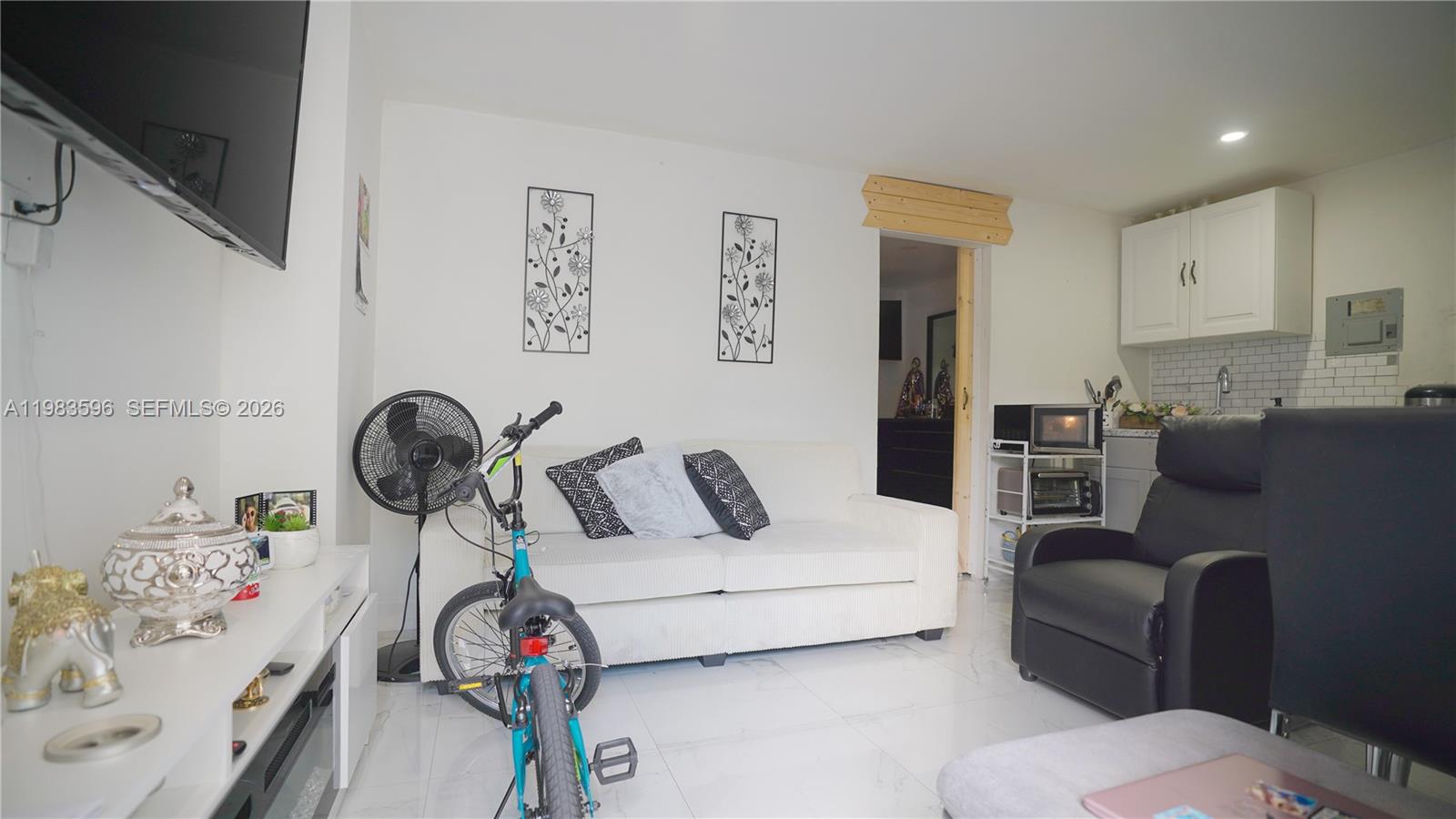 1720 Northwest 124th Terrace Miami, FL 33167 - Photo 45 of 73 a living room with furniture a rug and white walls