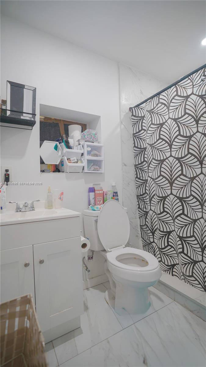 1720 Northwest 124th Terrace Miami, FL 33167 - Photo 54 of 73 a bathroom with a toilet sink and shower curtain