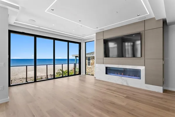 a large white kitchen with a large window and stainless steel appliances