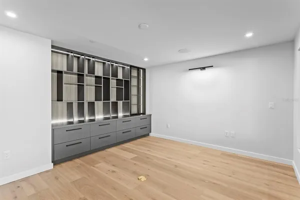 a large white kitchen with a large window a sink and stainless steel appliances