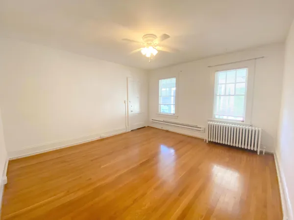 a view of empty room with wooden floor