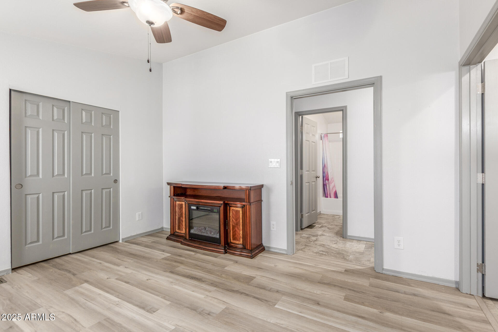 11425 East University Drive, Unit 115 Apache Junction, AZ 85120 - Photo 12 of 28 an empty room with wooden floor a ceiling fan and staircase