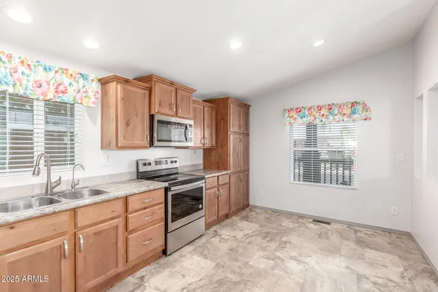 a kitchen with stainless steel appliances granite countertop a refrigerator stove a sink and a microwave