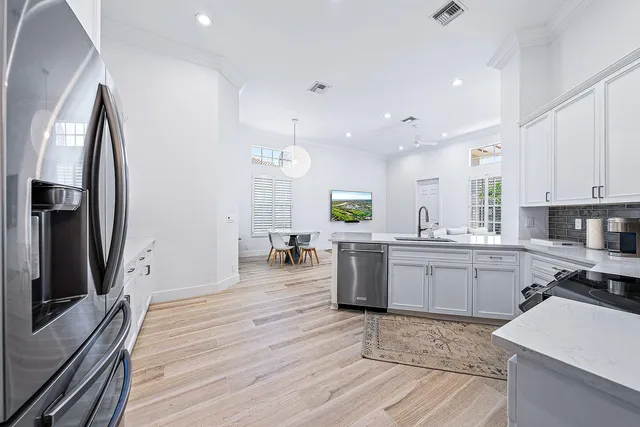 a kitchen with kitchen island granite countertop a sink stainless steel appliances and cabinets