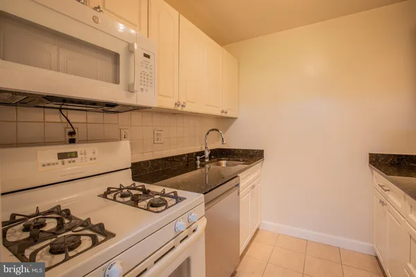 a kitchen with granite countertop a refrigerator and a stove