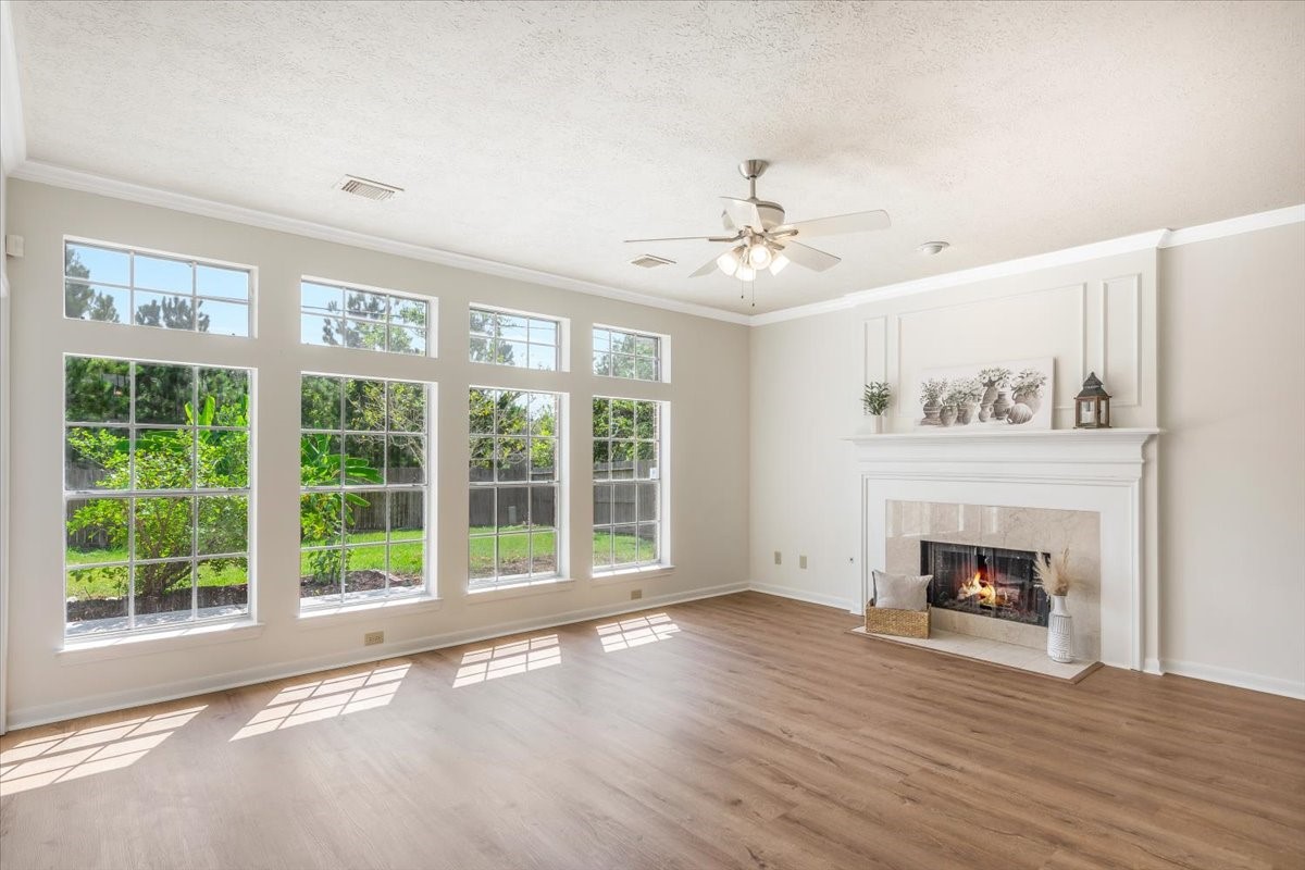 Light-filled living room with a fireplace, expansive windows, and beautiful backyard views.