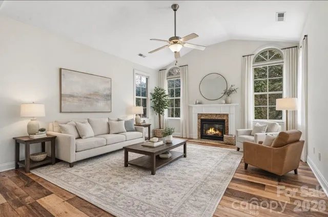 a living room with furniture a fireplace and a large window