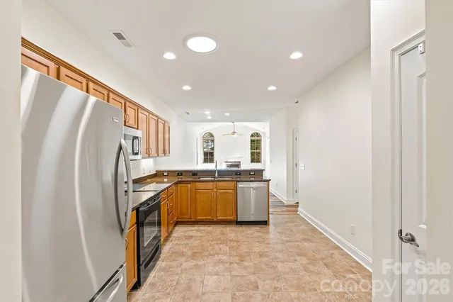 a kitchen with stainless steel appliances granite countertop a refrigerator and a stove top oven