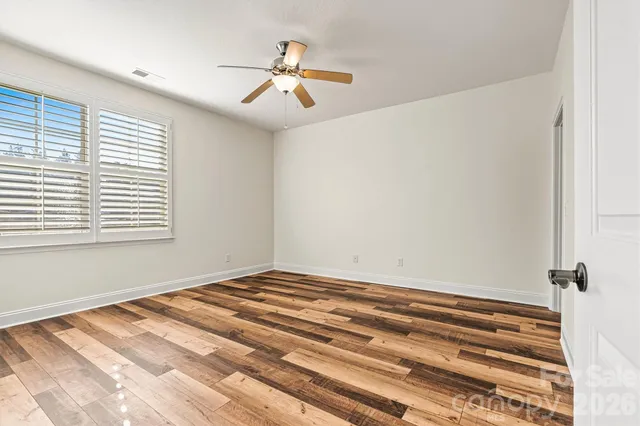a view of a room with wooden floor and fan