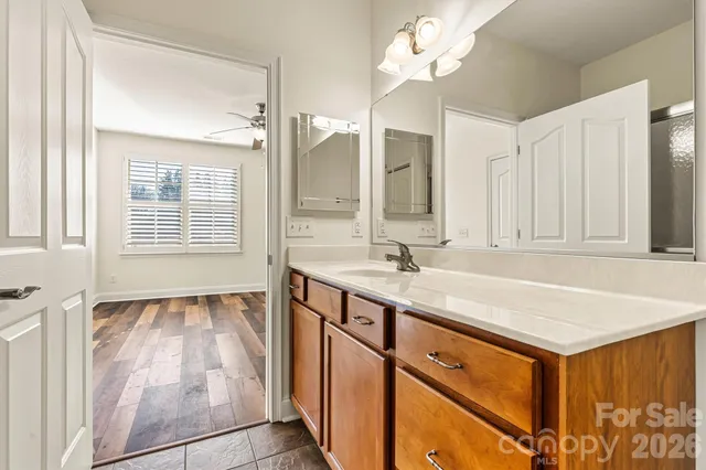 a bathroom with a sink vanity granite tub shower and a mirror