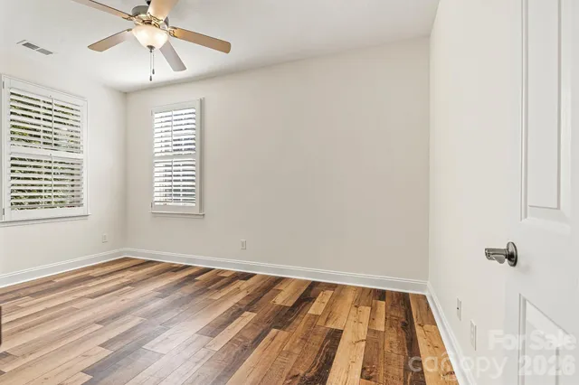 a view of a room with wooden floor and fan