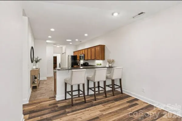 a kitchen with stainless steel appliances kitchen island granite countertop a refrigerator and a stove top oven