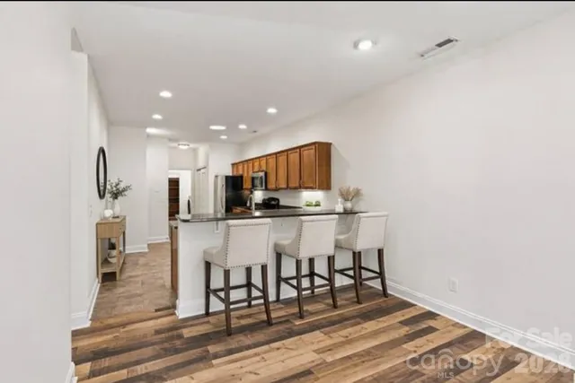 a kitchen with stainless steel appliances kitchen island granite countertop a refrigerator and a stove top oven