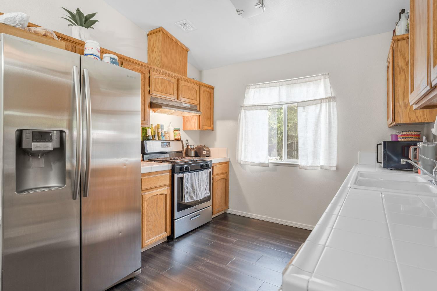 525 Tucker Sanger, CA 93657 - Photo 5 of 13 a kitchen with granite countertop stainless steel appliances a refrigerator stove top oven and sink