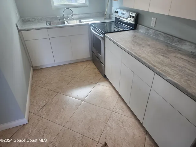 a kitchen with a sink stove and cabinets