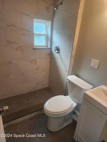 a white toilet sitting next to a shower