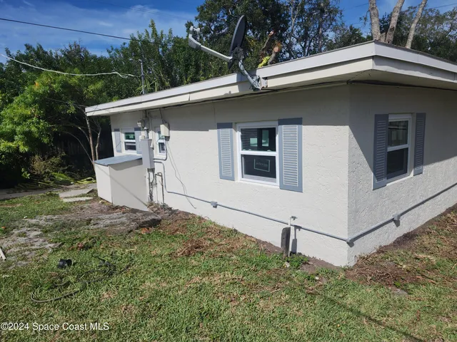 a white house with tree in the background