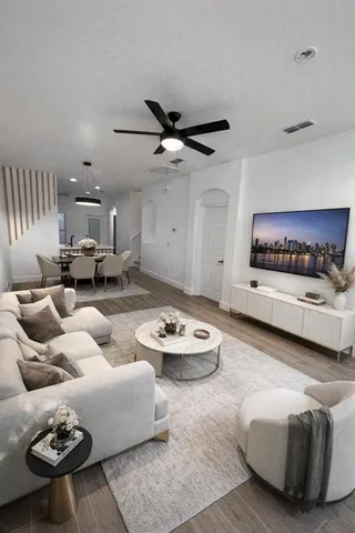 a living room with furniture and a ceiling fan