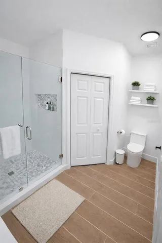 a bathroom with a granite countertop sink a toilet and shower