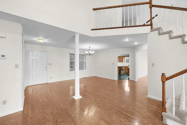 a view of an empty room with wooden floor and a large window