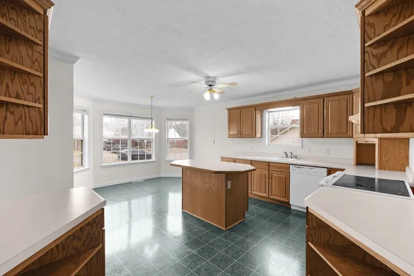 a view of a kitchen and a sink dishwasher wooden floor and a window