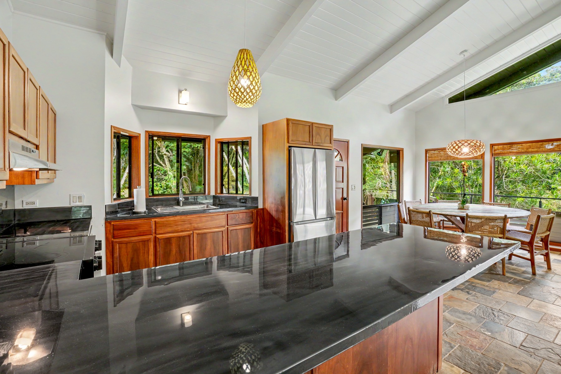 4470 A Wailapa Road Kilauea, HI 96754 - Photo 12 of 30 a kitchen with stainless steel appliances granite countertop sink stove and wooden cabinets
